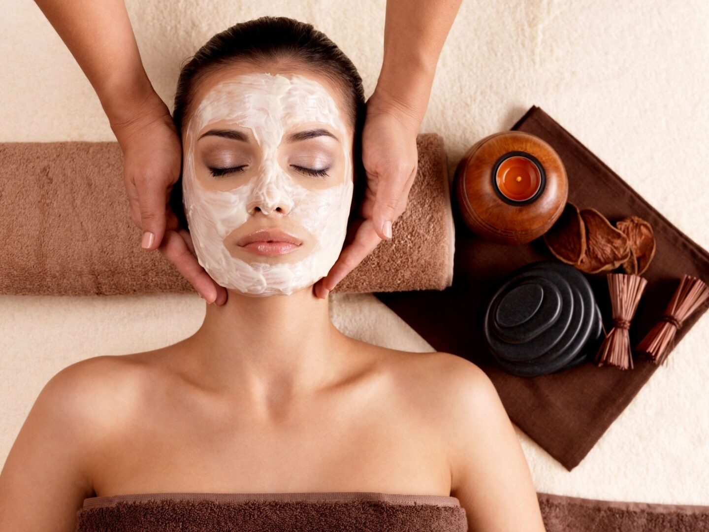 A woman getting her face washed with clay