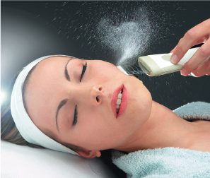 A woman getting her face cleaned with an electric device.