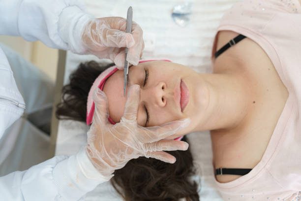 A woman getting her face waxed at the salon